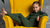 Little girl sitting on yellow armchair and wearing dark green matching set from Merino wool