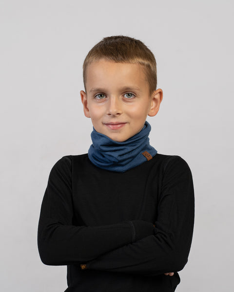 Boy wearing a blue Merino wool neck gaiter with black base layer – soft, breathable, and comfortable kids’ winter accessory.