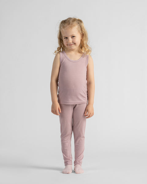 Full-length view of a young girl standing straight and facing forward, dressed in a matching mauve sleeveless top and fitted leggings.