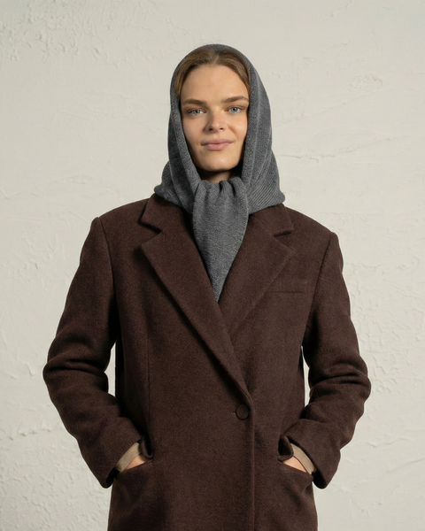 Woman wearing dark gray merino wool bandana as a shawl-style wrap.