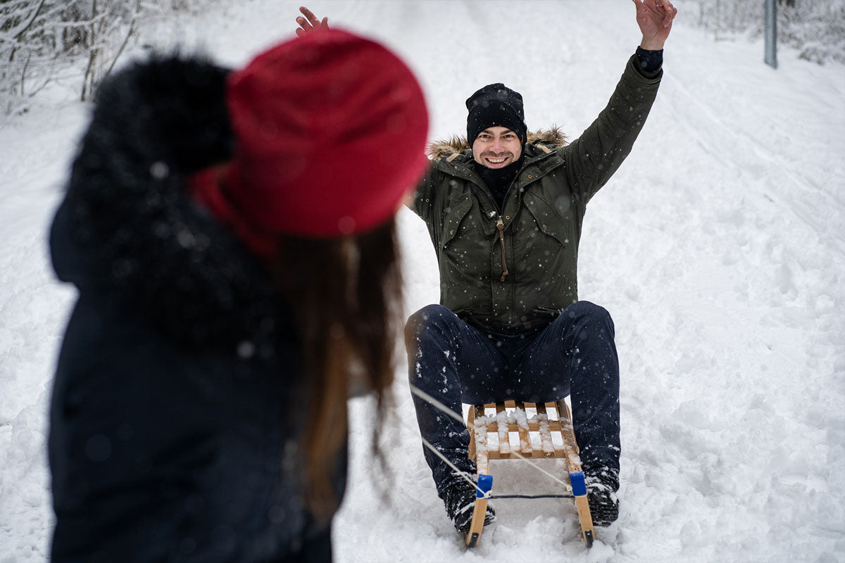 Woman pulling winter sleds with husband on them