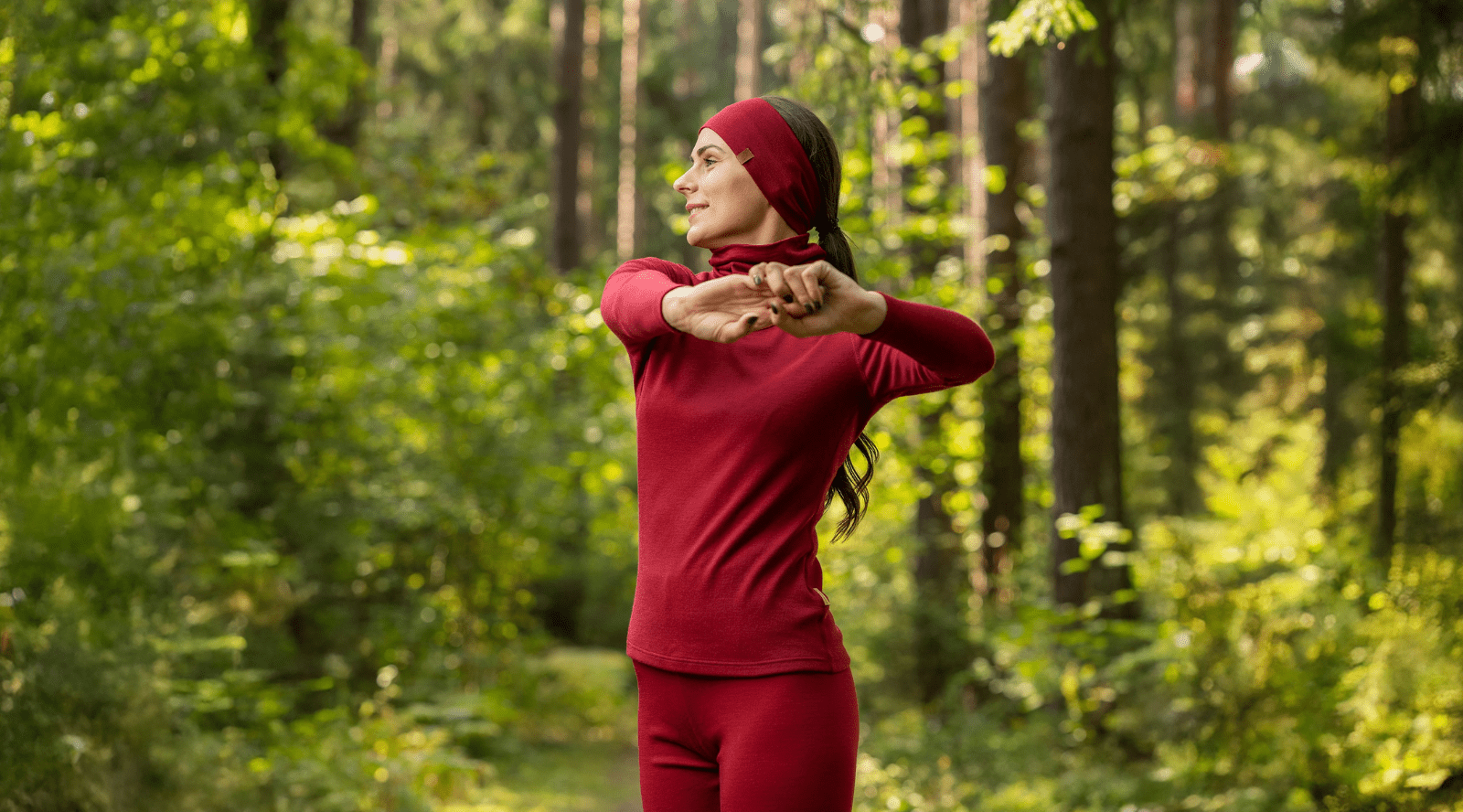 Woman sitting outdoors and wearing red leggings and black long sleeve top