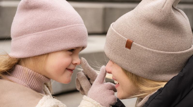 a woman and a girl wearing cashmere and merino wool blend beanies and gloves.