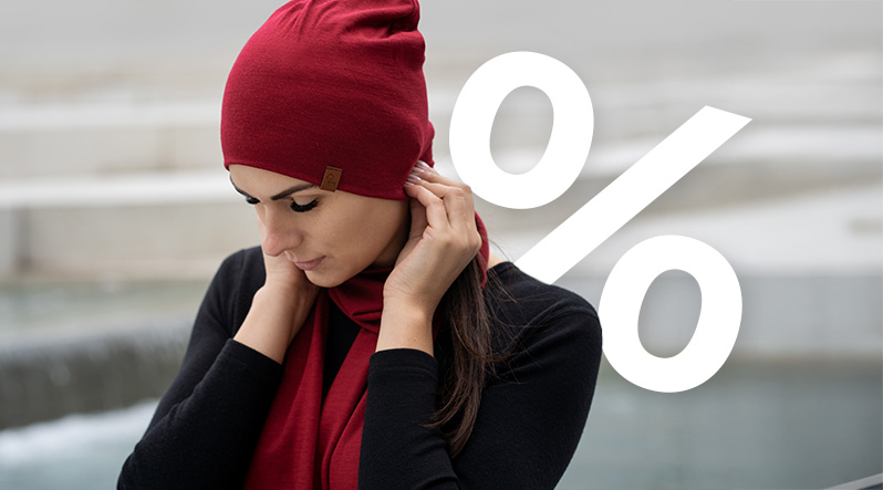 a woman doing sit ups outside, wearing a royal cherry color merino headband and matching color merino bottoms. She is also wearing a long sleeve merino shirt in black. The text of the banner reads "UP TO 40% OFF".