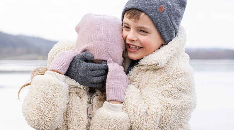Kids playing outdoor and wearing warm Merino wool and cashmere beanies
