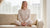 Woman sitting in lotus pose on the sofa and wearing natural merino wool matching set