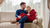 Man and woman sitting on the couch and hugging. Wearing Merino wool clothing
