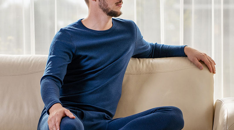 Man sitting on the sofa and wearing Merino wool long sleeve top