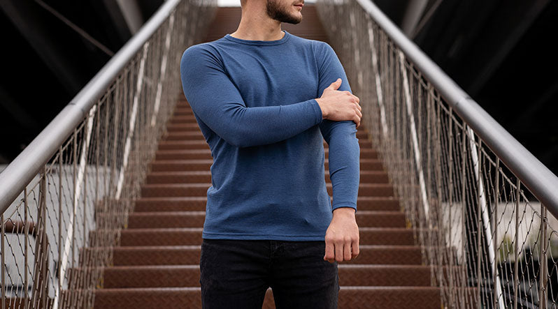 Handsome young man in Merino wool sports clothing long sleeve top standing outside. 