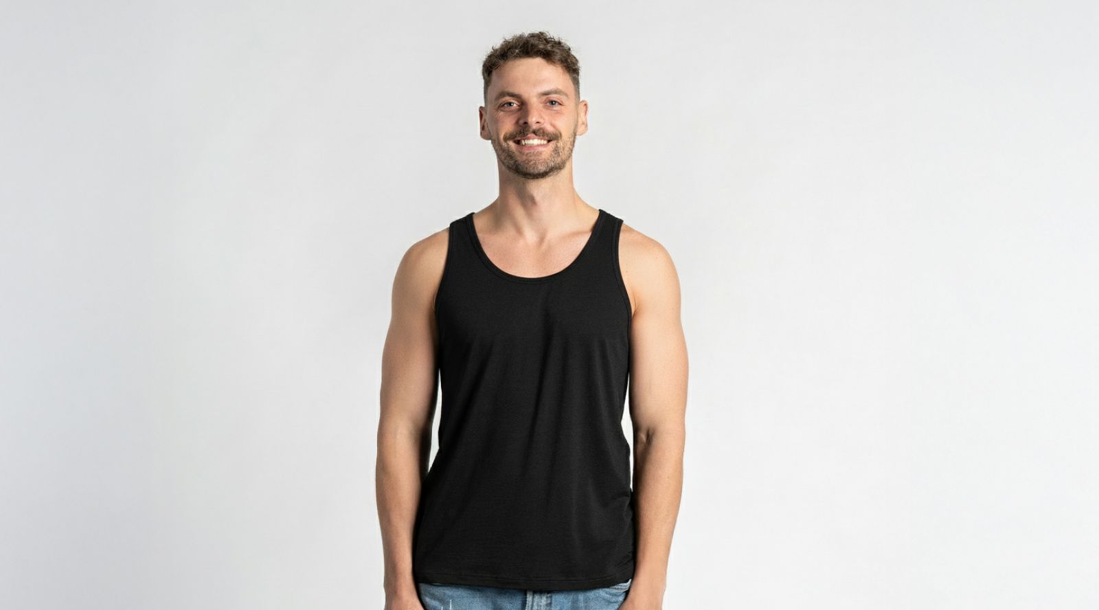 Man wearing a black tank top against a plain background