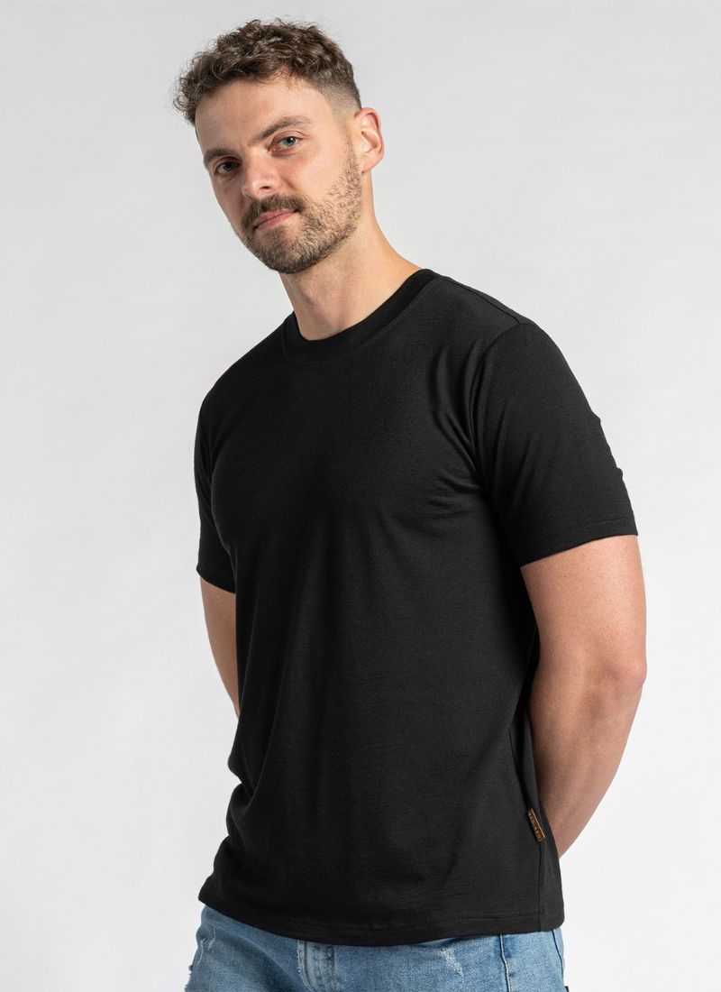 Man wearing a black t-shirt and blue jeans against a white background