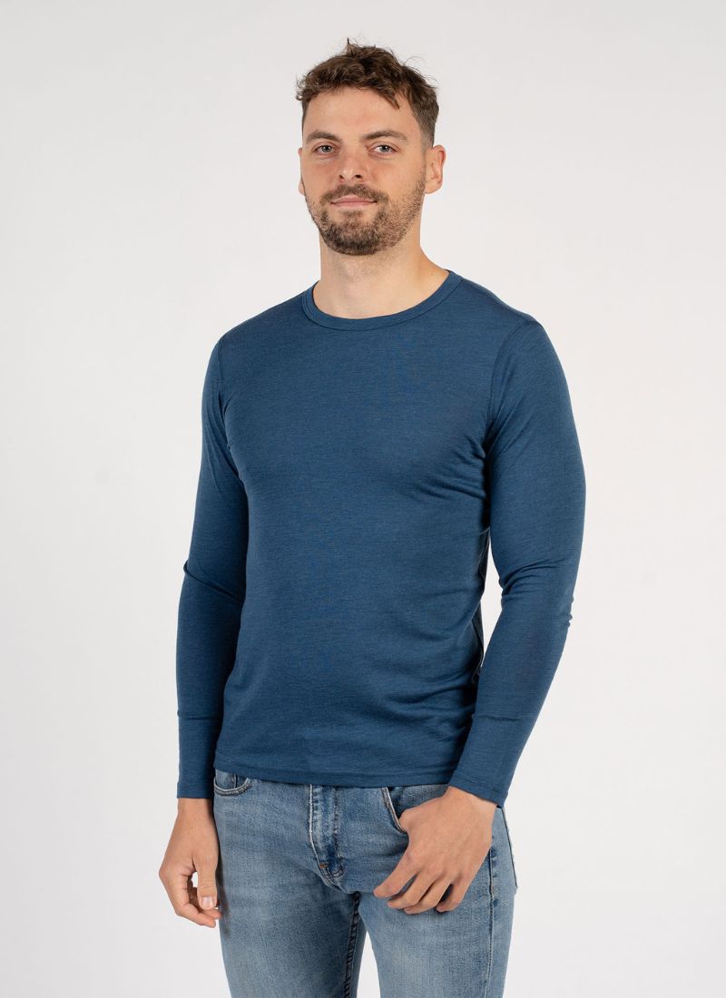 Man wearing a blue long-sleeve shirt and jeans on a white background