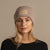 Woman wearing merino wool long sleeve top and knitted merino wool beanie with MENIQUE logo