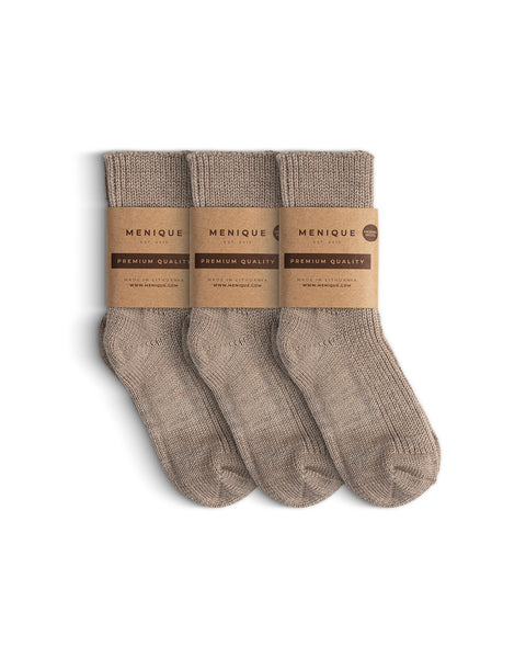 Set of three pairs of beige ribbed thick kids’ socks, each wrapped in a Menique brown paper label marked ‘Premium Quality.