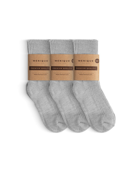 Set of three pairs of light gray children’s ribbed thick socks, neatly arranged and wrapped with Menique ‘Premium Quality’ brown paper bands.