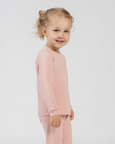 Side view of child in pink bamboo long-sleeve top and bottoms.