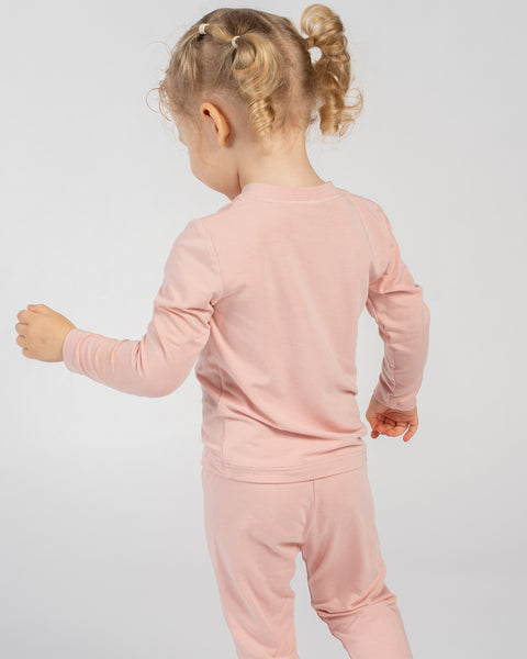 Child in pink bamboo long-sleeve top and bottoms, shown from the back while walking.