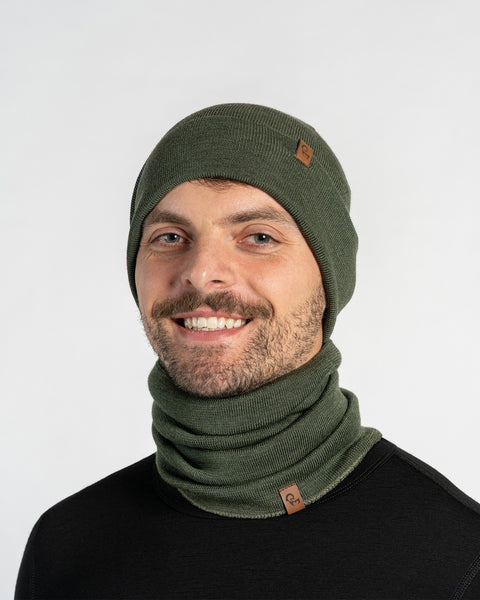 Man wearing a green knit beanie and scarf set on a white background