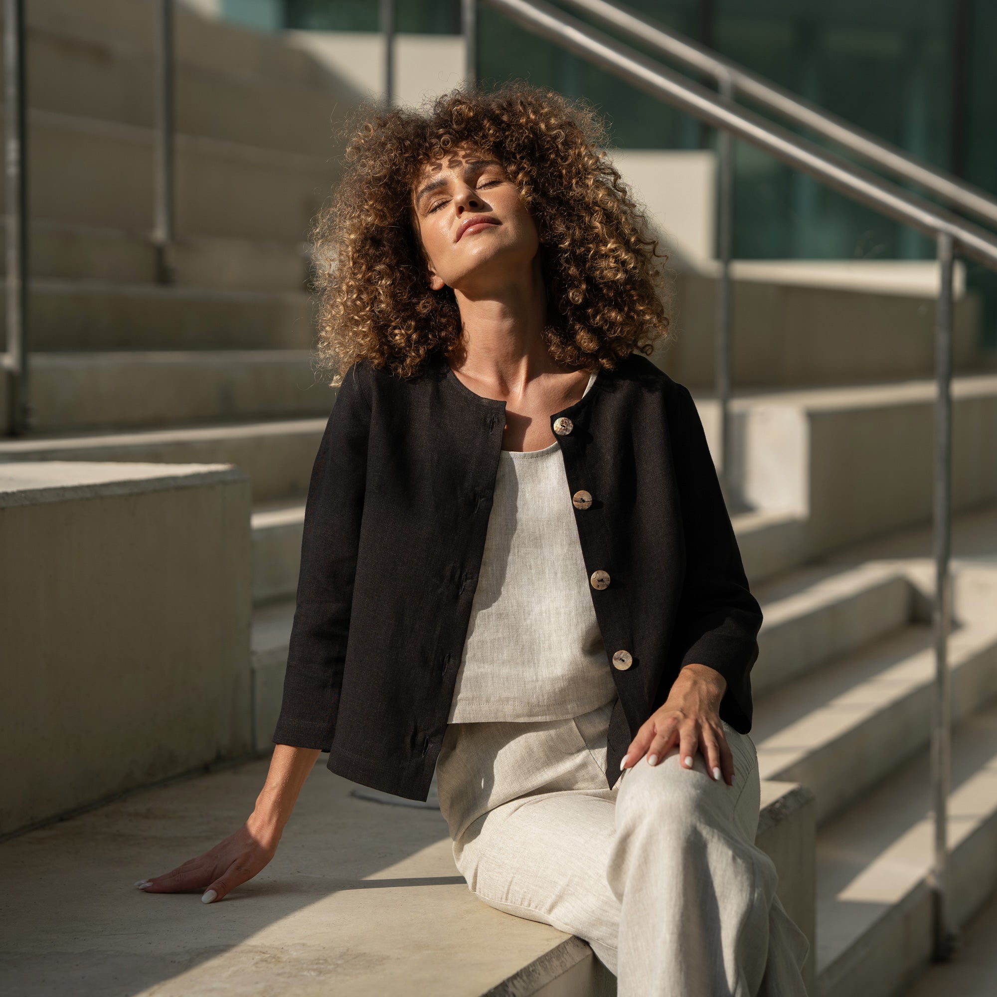 Woman with curly hair wearing natural linen jacket Alice