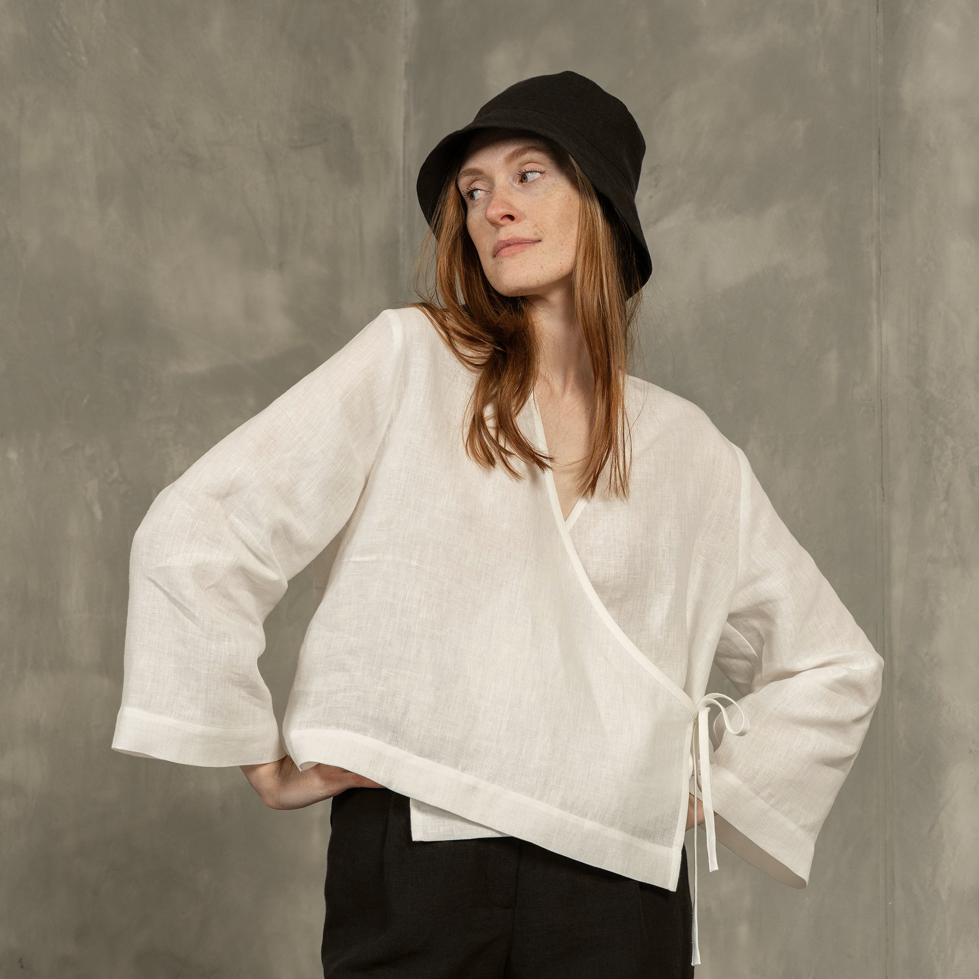 Woman wearing Linen bucket hat in storm blue color and linen blouse in pure white color