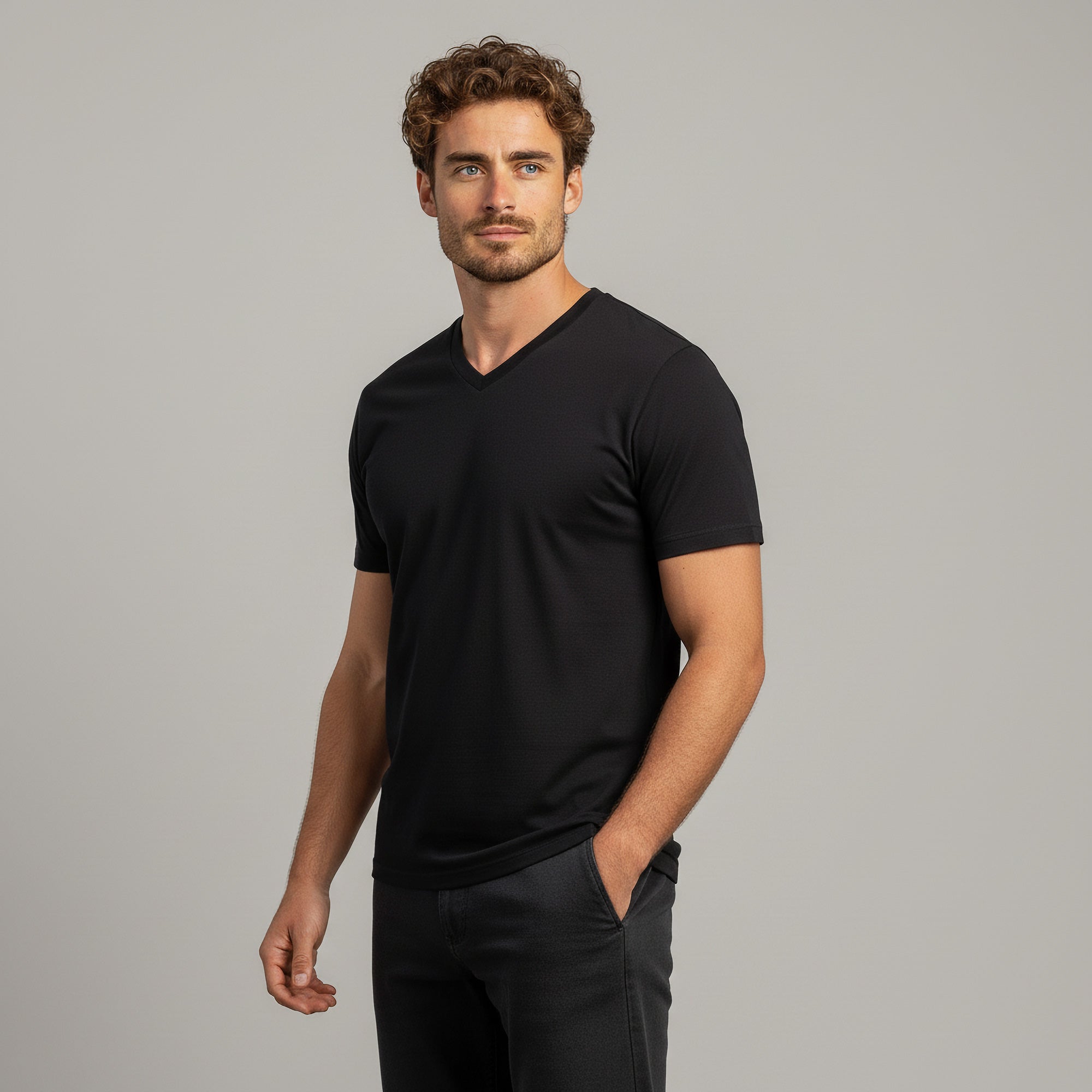 Man wearing a blue V-neck t-shirt against a gray background