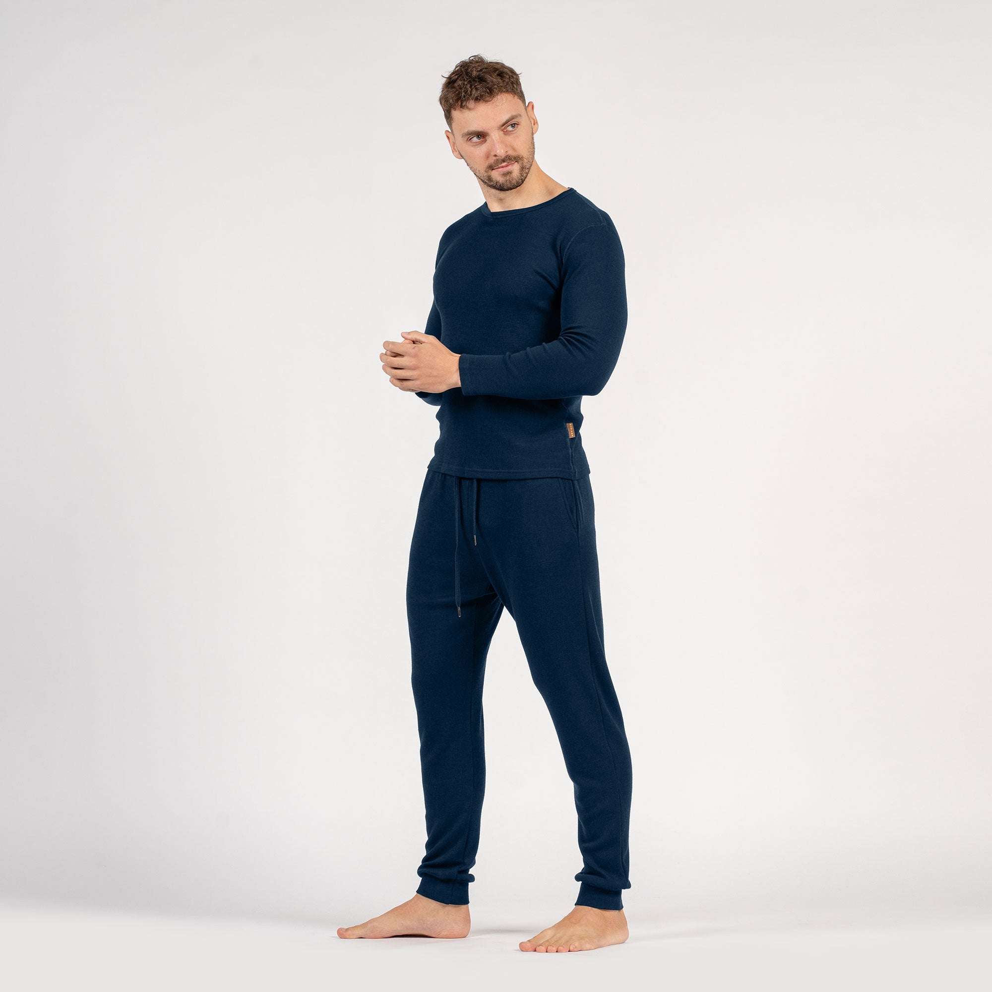 The menique men's merino wool 250gsm long sleeve top and jogger sweatpants set in black color.