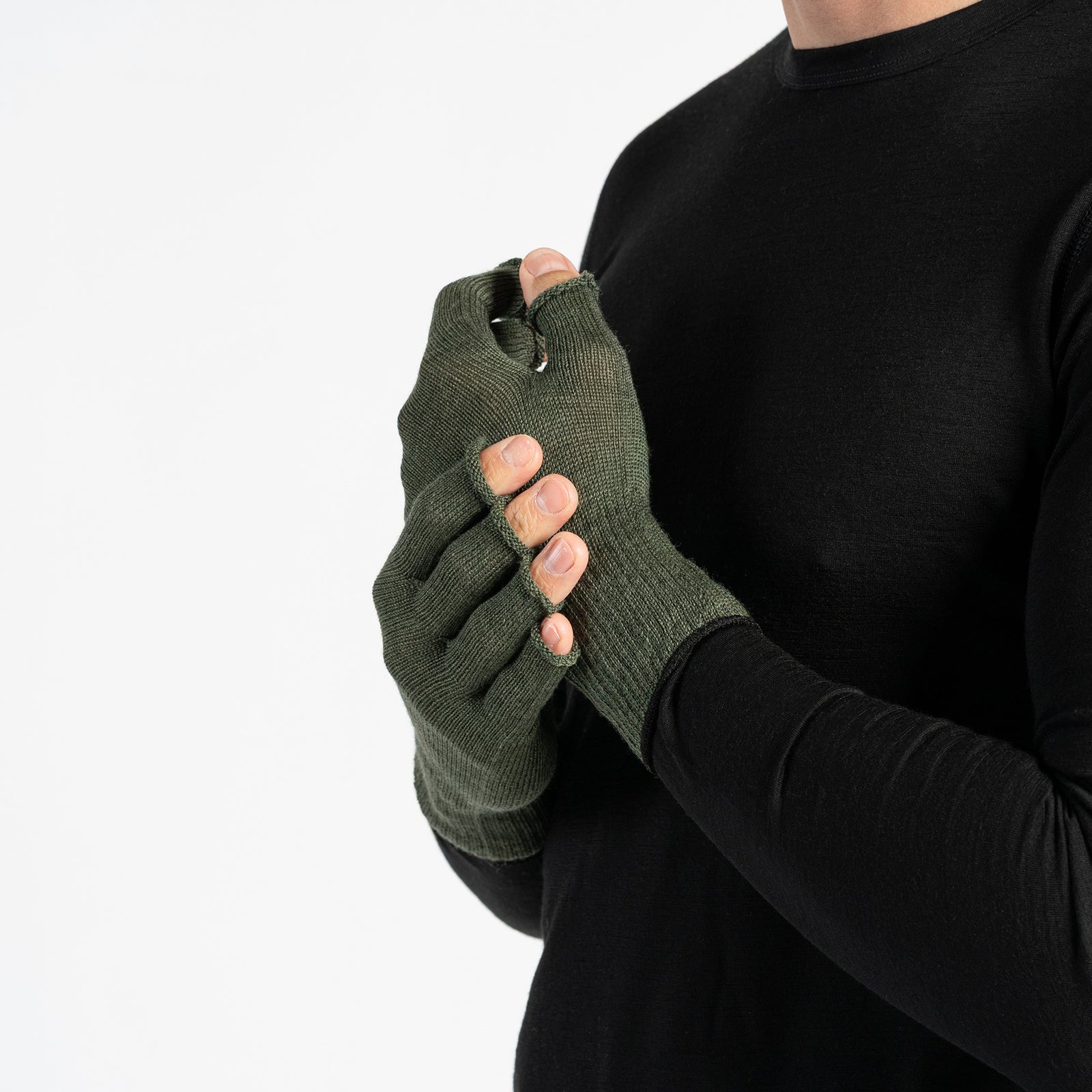 A person wearing a black long-sleeved shirt is shown from the chest up, putting on black fingerless gloves. The background is white.