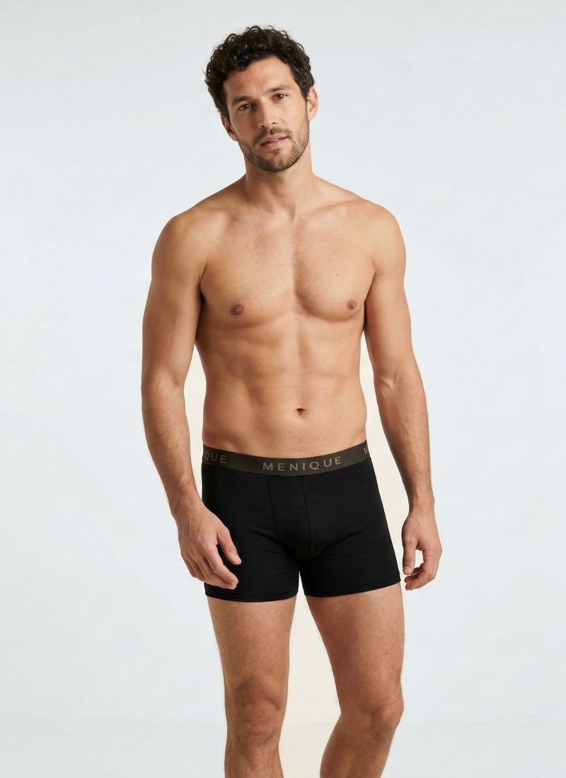 Man wearing black merino wool boxer briefs with elastic waistband, breathable men’s merino wool underwear designed for moisture-wicking comfort, temperature regulation, and everyday base layer wear.
