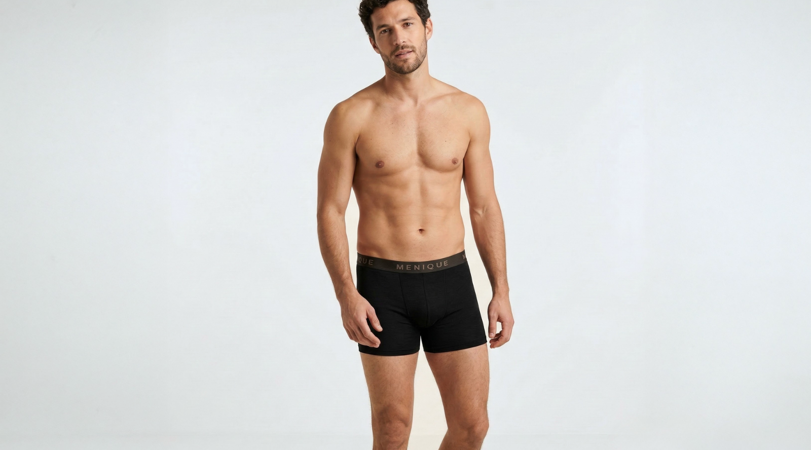 Man wearing black merino wool boxer briefs with elastic waistband, breathable men’s merino wool underwear designed for moisture-wicking comfort, temperature regulation, and everyday base layer wear.