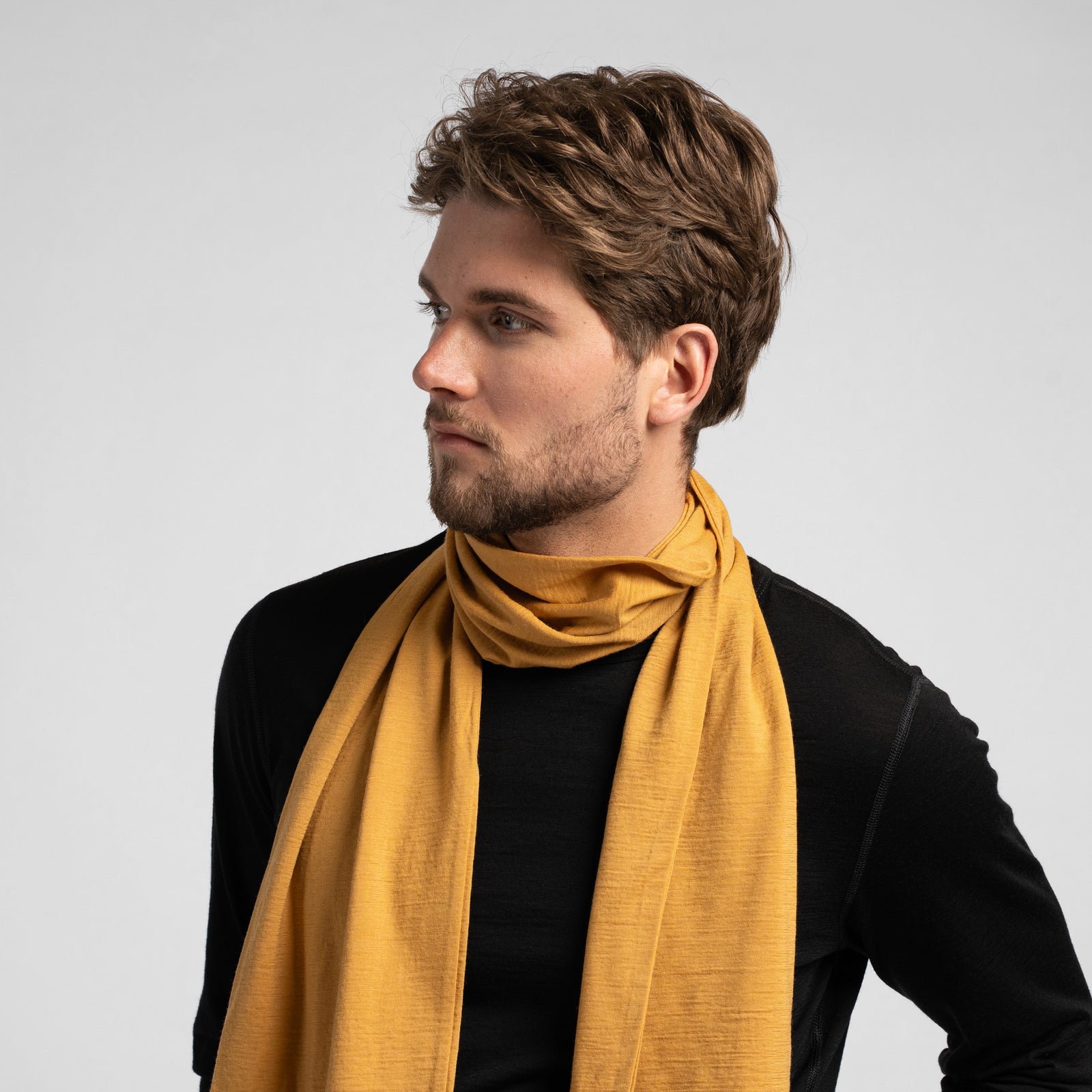 Long yellow merino wool scarf isolated on white background, breathable natural wool accessory for men and women.