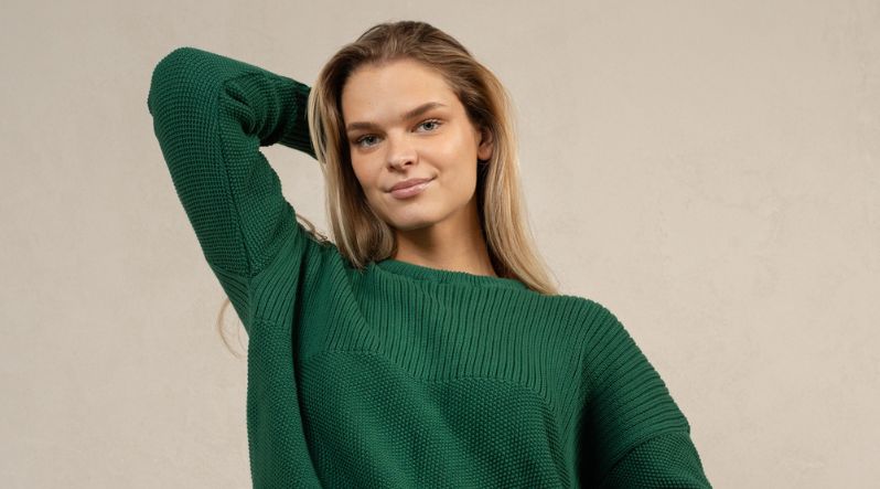 Smiling woman wearing dark green sweater 