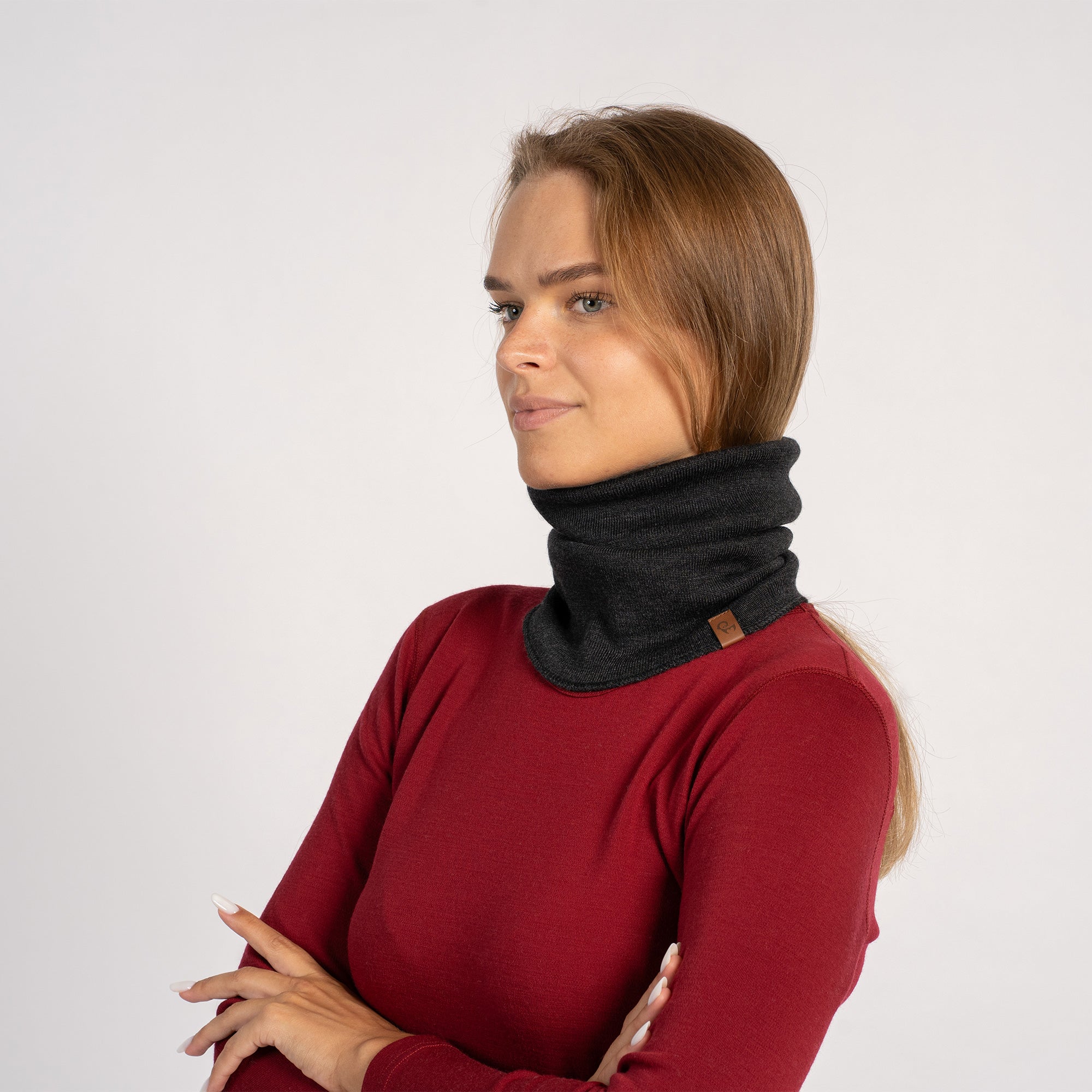 Woman in red shirt with dark gray knitted Merino wool gaiter pulled up over the face, side view.