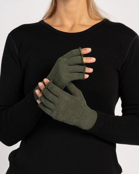 Frontal view of a woman in a black top modeling dark-green fingerless gloves, one hand raised and the other clasping it.