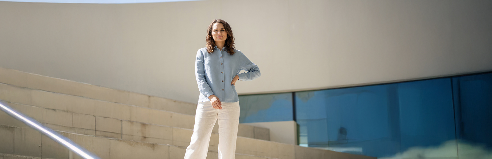 Woman standing on a staircase with a modern building in the background