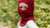 Little girl standing outdoors and wearing red balaclava face mask