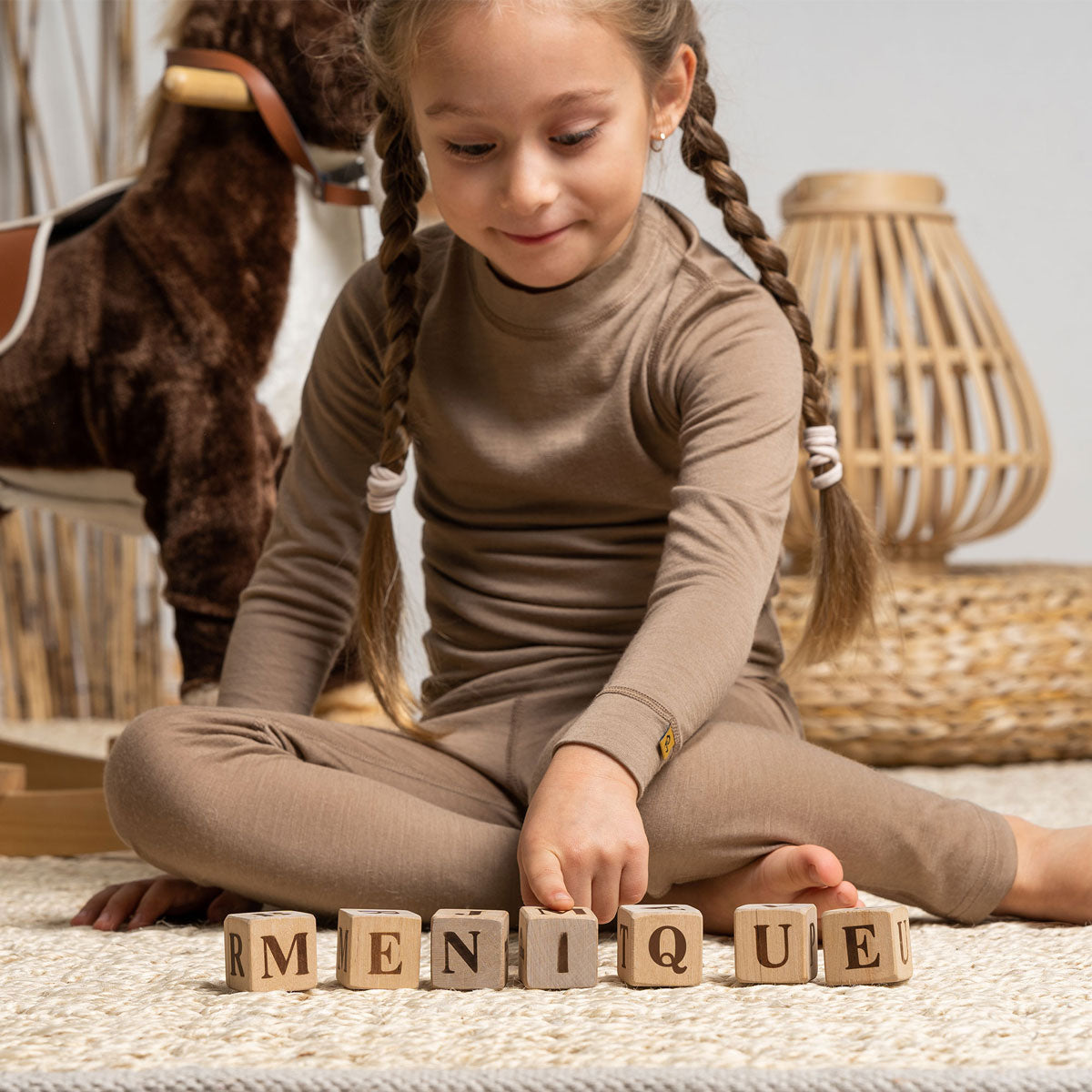 the menique kids' 160gsm merino long sleeve top in beige color, front view.