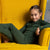 the menique 160gsm kids' merino set of long sleeve top and pants in dark green, front view.