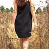 Woman walking through tall grass while wearing linen slip dress in b;ack color